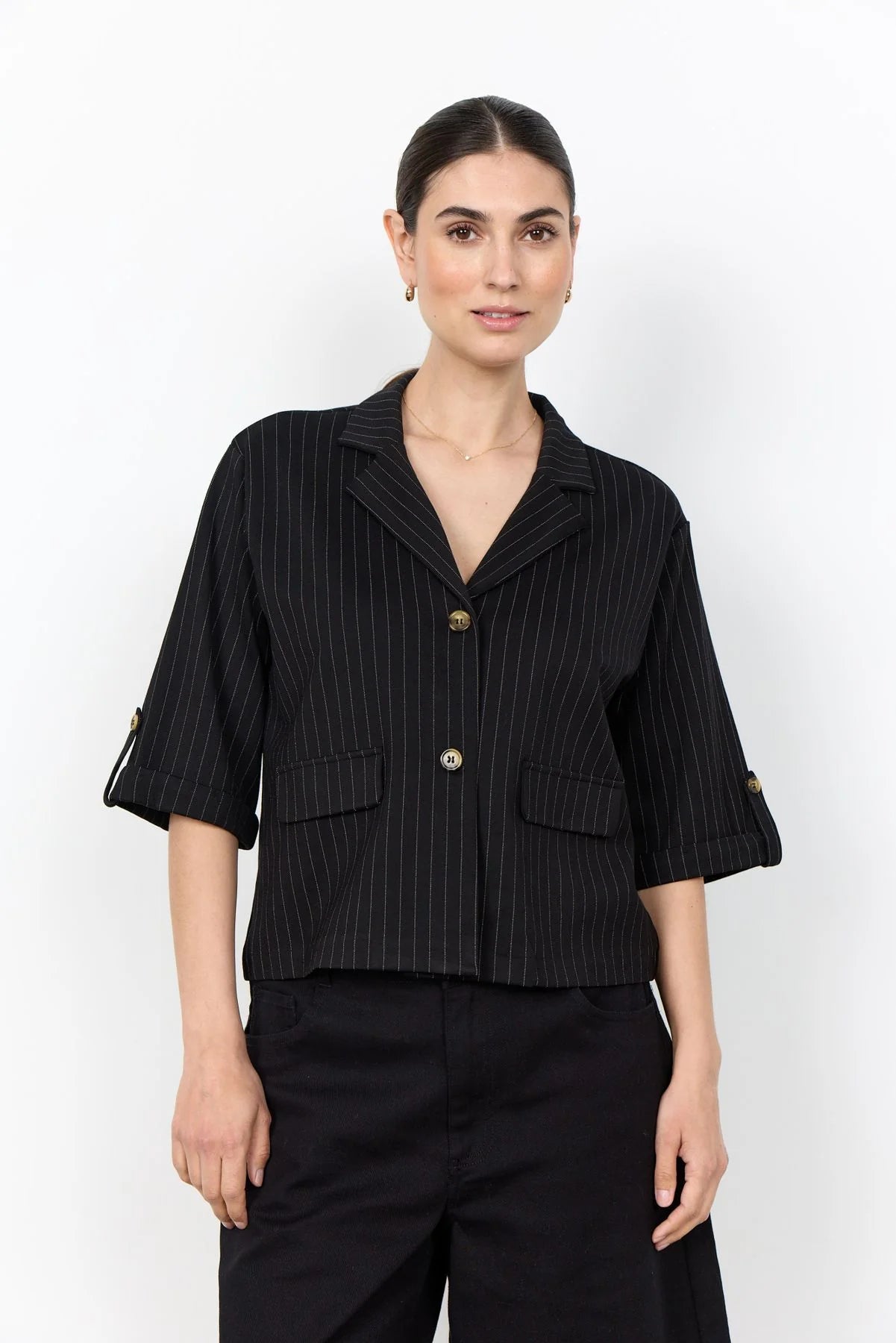 Schwarze Nadelstreifen-Bluse mit Kragen, Knopfleiste und 3/4-Ärmeln vor hellem Studiohintergrund.